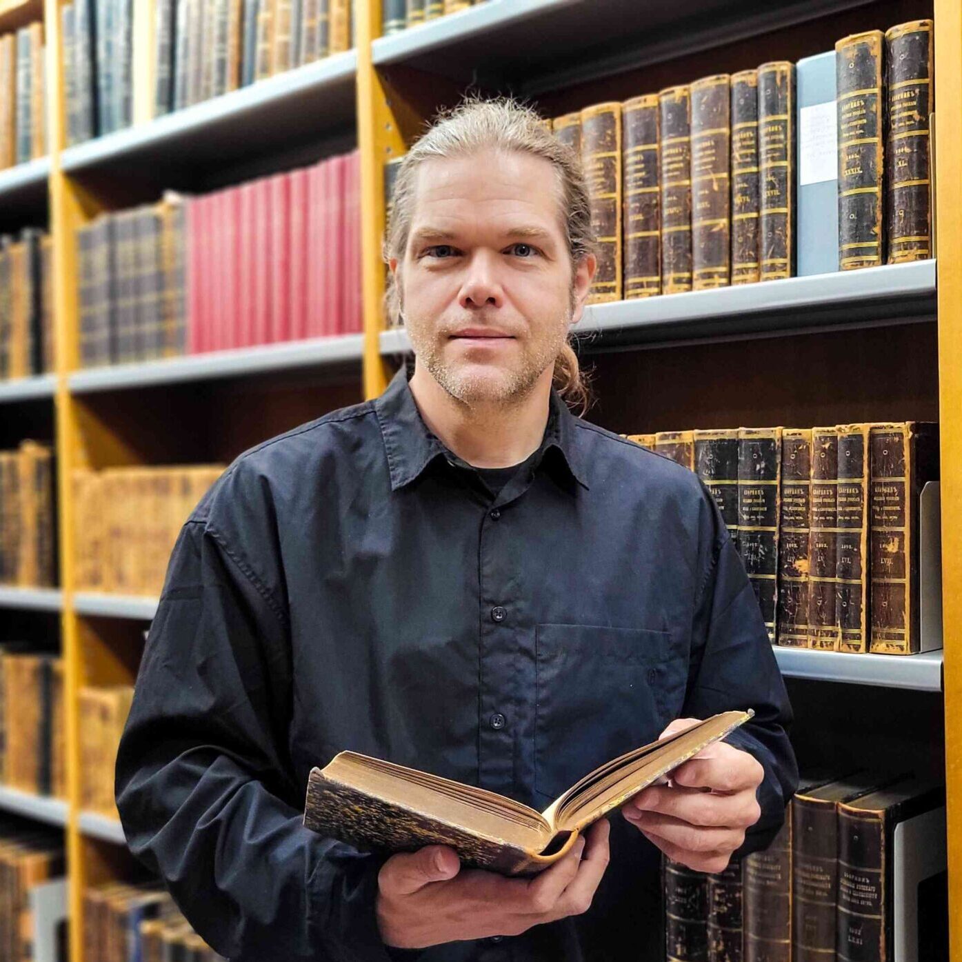 Raymond Drause at the National Library of Finland holding a book